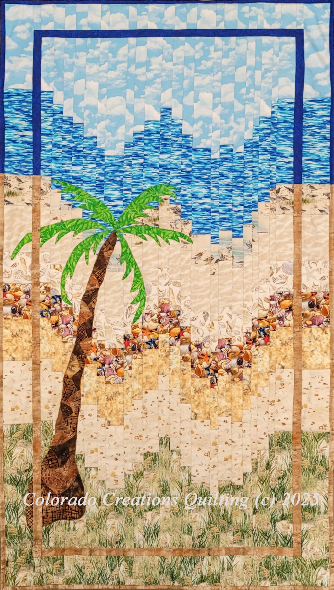 The Beach Bargello quilt kit features a large palm tree in front of a beach scene complete with sand, seashells, and ocean waves using the bargello quilt technique