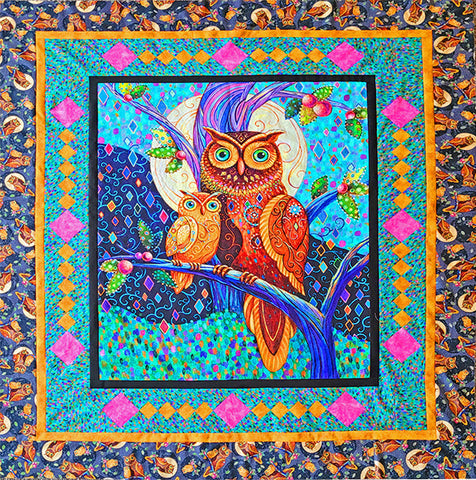 The quilt pattern uses a center panel with highly detailed designs on the owls perched on a tree branch.