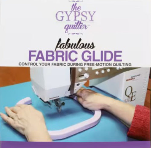 Sewing machine with a fabric glide attachment on  blue fabric, with text about 'The Gypsy Quilter' and 'Fabulous Fabric Glide'.