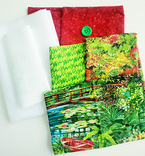 Set of fabric samples with various patterns including a red fabric with a green button, white fabric, green leaf-patterned fabric, and a colorful nature scene.