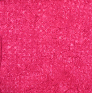 The bright pink tonal batik fabric with small x's. Available at Colorado Creations Quilting