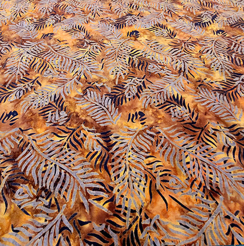 This batik cotton fabric features grayish palm branches on a rich brown  background. Available at Colorado Creations Quilting