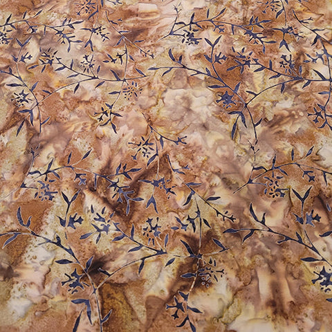 This batik cotton fabric features black vines and small flowers on a rich brown background. Available at Colorado Creations Quilting