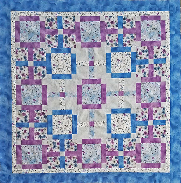 Quilt done in large blocks with narrow rectangles used for separation in  blue, purple, white and gray