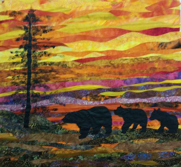 Evening Stroll landscape quilt shows a silhouette of an evergreen tree and three bears strolling with a golden sunset above.  Available at Colorado Creations Quilting
