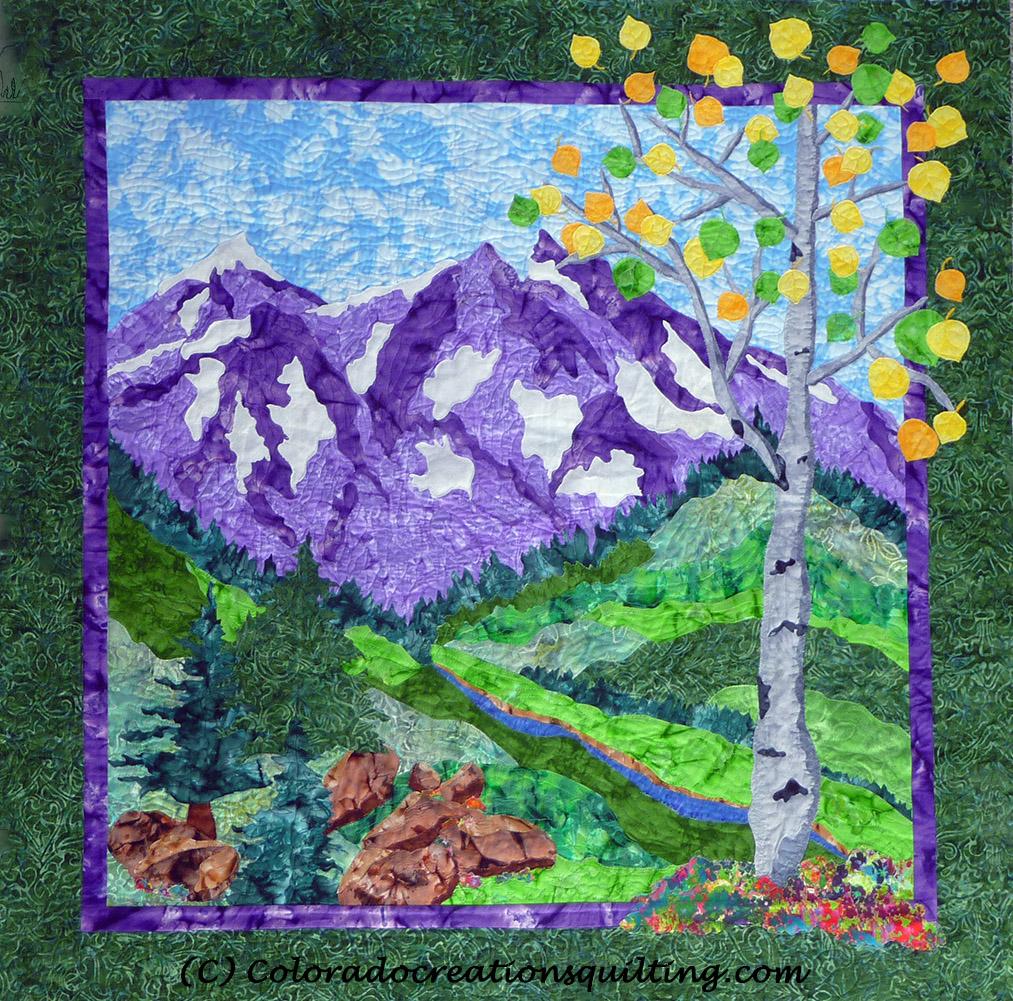 Purple mountains soar above green hills, boulders and an aspen tree.  Quilt pattern available at Colorado Creations Quilting