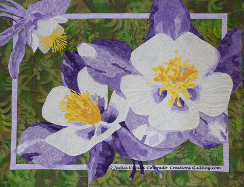 Colorful Columbine art quilt to hang on the wall has 2 flowers and a bud in shades of purple