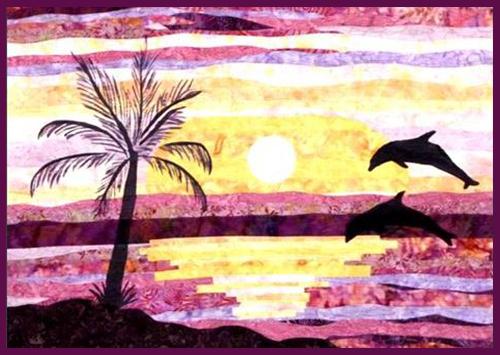 Dancing Dolphins Landscape Mixed Media Quilt Kit features 2 dolphins jumping out the ocean with a palm tree in the foreground.  All the sunset-colored fabric is also displayed