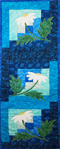 This darling little one of a kind art quilt features white appliqued daisies in the middle of blue log cabin quilt blocks. 