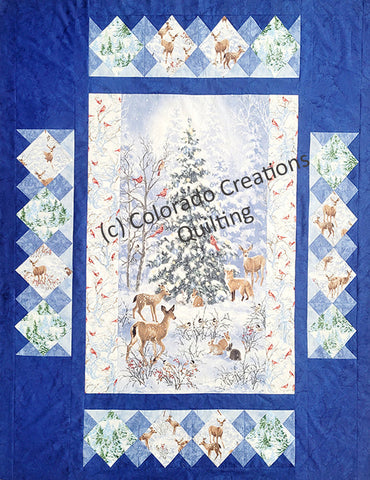 This quilt pattern features a central panel features a snow-covered evergreen tree surrounded by darling forest wildlife like deer, rabbits, cadinals. Multiple borders span outward from there featuring trees and deer blocks set on point. Pattern available at Colorado Creations Quilting