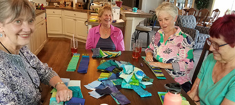 Quilters swapping fabric at Game Night. Trading dice and game nights sign-ups are available at Colorado Creations Quilting