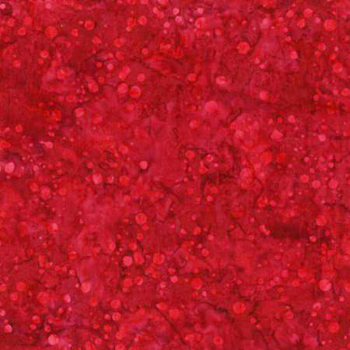 This batik fabric features dots in cranberry red.