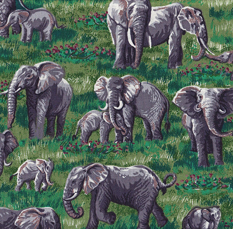This fun novelty cotton fabric print features elephants (both young and old) on green grass