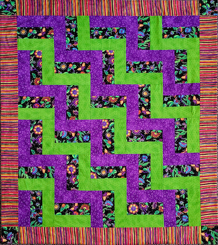 This handmade quilt features rectangles in bright purples, greens, and flowers on black the rail fence fashion and surrounded by a fun striped border print. Designed by Jackie Vujcich, this quilt measures approximately 44"W x 52"L.