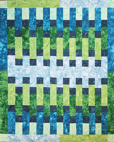 Quilt done in with rows of alternating rectangles in blues and greens. 