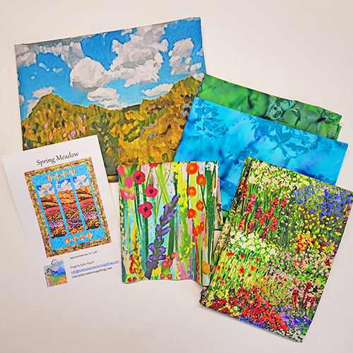  Display of all  fabrics needed for the Spring Meadow quilt kit available at Colorado Creations Quilting.  Fabrics feature a panel with a meadow of brightly colored wild flowers, a blue background, and an outer border of tiny wild flowers.