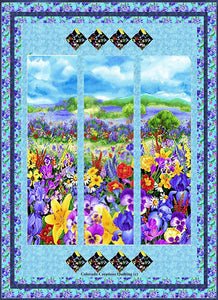 Wild Meadow quilt pattern available at Colorado Creations Quilting.  Fabrics feature a panel with a meadow of brightly colored wild flowers, iris on a blue background, and blender navy and aqua blues.
