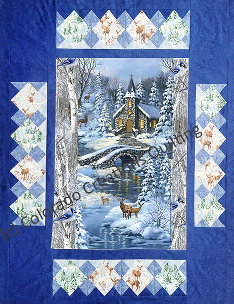 This pattern features a central panel with a cobble-stone bridge over a river and a snow-covered country church with yellow lighting in the distance. Wildlife like deer surround the snowy evergreen trees.  Multiple borders span outward from there featuring trees and deer blocks set on point. Pattern available at Colorado Creations Quilting