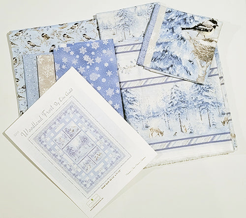 Quilt center features a fabric panel with five blocks; the largest features snow-covered evergreen trees in blue tones. The other four blocks show a snowy owl, rabbit, deer and chickadees. Available at Colorado Creations Quilting