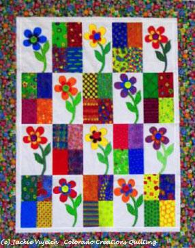Flower Power Quilt:alternates pieced 4-patch squares and appliqued flower on white background with a surrounding border available at Colorado Creations Quilting