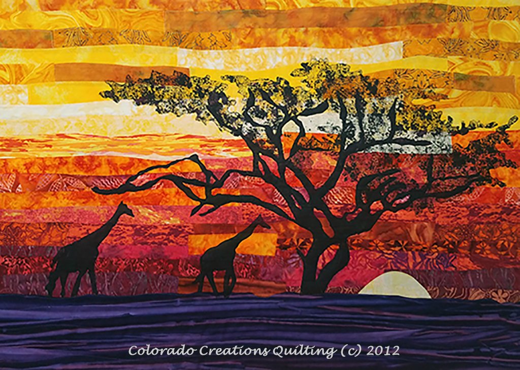 Two giraffes in silhouette strolling passed a moonlit tree, a orange/red/yellow sunset sky and all the fabric needed to complete the quilt top.  Across the Serengeti quilt kit available at Colorado Creations Quilting.