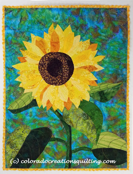 One sunflower on a blue background.  Quilt pattern available at Colorado Creations Quilting