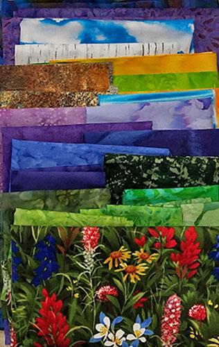  Display of all  fabrics needed for the Mountain Escape quilt kit available at Colorado Creations Quilting.  Fabrics feature richly-colored batiks and an amazing wildflower print.