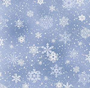This cotton fabric features white snowflakes on a light blue background. Available at Colorado Creations Quilting