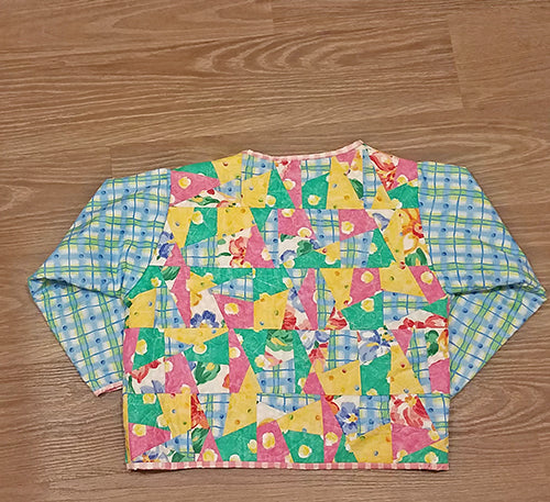 This darling quilted one of a kind jacket (back side) in florals and pastels will definitely make a statement! Available at Colorado Creations Quilting