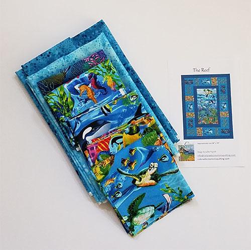 The Reef quilt pattern by Jackie Vujcich is a tribute to life under the sea. Start with a wonderful fabric panel by Timeless Treasures and add in coral, sea turtles, sea horses, killer whales, tropical fish and more. Panel and coordinateing blocks are surrounded by blue borders. This kit shows all the fabric included along with the pattern. Available at Colorado Creations Quilting