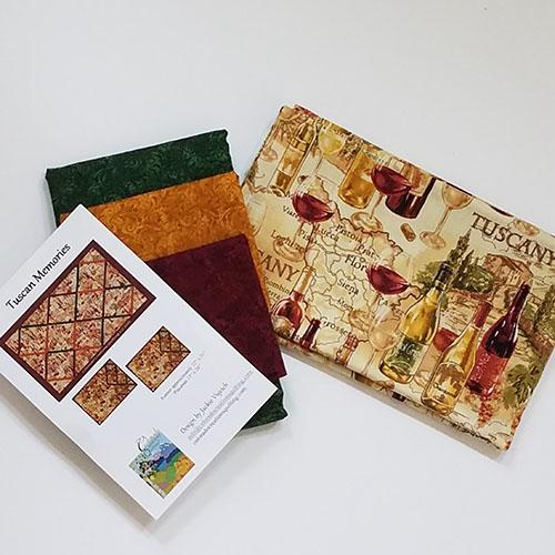 Display of all fabrics (wine print, red, green, gold) needed for Tuscan Memories quilt pattern by Jackie Vujcich of Colorado Creations Quilting