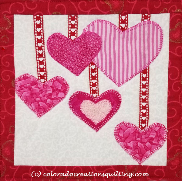 Pink hearts appliqued on a quilted square to hold your coffee cup