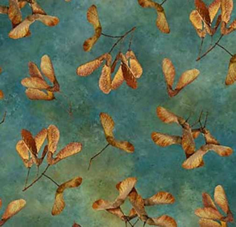 This cotton quilting fabric features large fall-colored whirligig leaves on a teal blue background