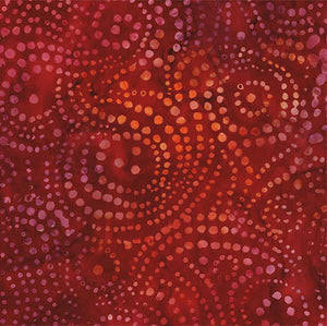 This batik tonal fabric features swirling red dots in a deep red.