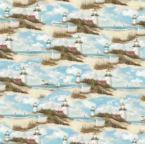 Images of serene lighthouses, sailboats and white beach fences are featured on a background of blue skies above blue ocean waters. Available at Colorado Creations Quilting