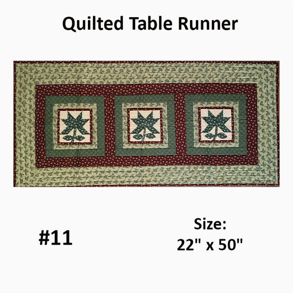 This quilted runner has blocks featuring pieced shamrocks in shades of green. Designed by Jackie Vujcich.