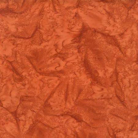 This batik tonal cotton fabric features a rich rust color.