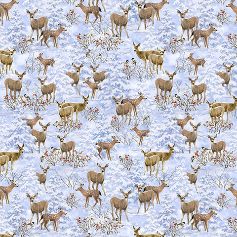 This cotton fabric features small deer among bushes with red berries and snow-covered evergreen trees in shades of blue and gray.